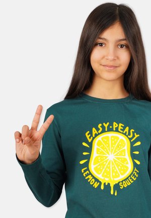 Grünes Langarmshirt mit einem gelben Zitronen-Grafik und dem Text "EASY-PEASY LEMON SQUEEZY." Das Design ist auf weichem Stoff gedruckt.