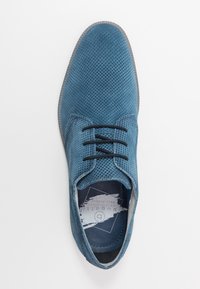 Chaussure en maille bleue présentant un bout arrondi, un design à lacets et une surface texturée. Lacets noirs avec une doublure douce et une semelle contrastante.