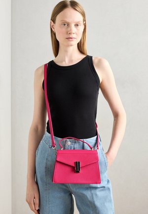 Roze gestructureerde handtas met een klepluiting en zwarte accenten. Gedragen als crossbody met een lange schouderband. Gladde textuur.