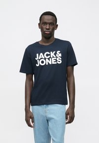 Marineblå bomulls-T-skjorte med rund hals og korte ermer. Har fet hvit "JACK & JONES" skrift på forsiden.