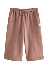 Shorts large en tissu doux de couleur rose clair, avec une taille élastique, un cordon de serrage et des poches latérales. Présente un petit patch logo.