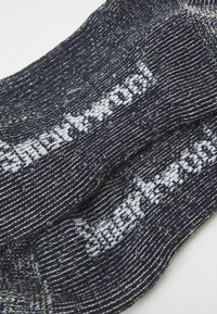 Calze blu navy con una texture a macchie bianche, caratterizzate dal logo del marchio in bianco. Lunghezza alla caviglia con un design a maglia liscia.