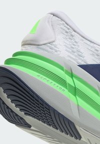 Sneaker features a textured white mesh upper, green accents, a padded collar, and a multi-patterned rubber outsole with "REPETITOR" branding.
