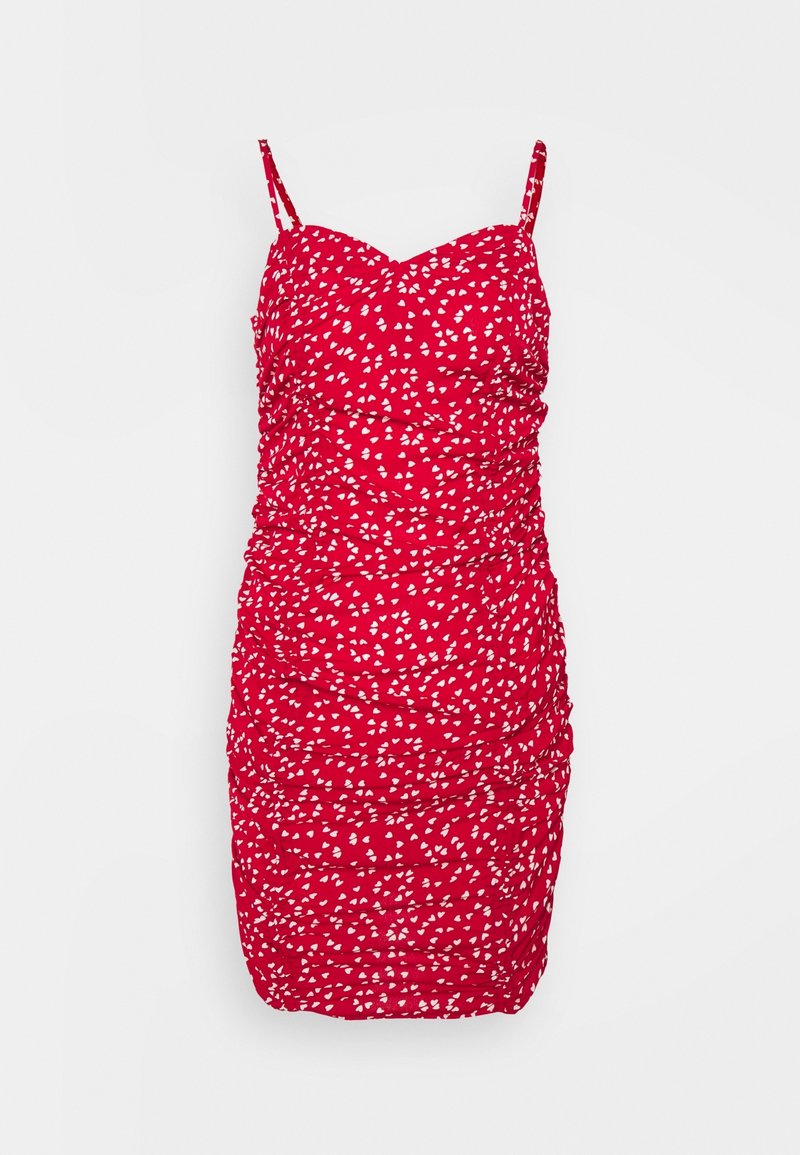 Mini robe rouge froncée avec fines bretelles et motif de cœurs blancs éparpillés.