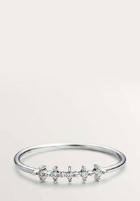 Anillo de plata con una banda delgada, que presenta cinco piedras transparentes engastadas en garras dispuestas en un patrón lineal. Acabado liso y pulido.