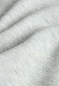 Světlé šedé látky s měkkou, hladkou strukturou. Materiál se zdá být mírně elastický s jemným melírovým vzorem.