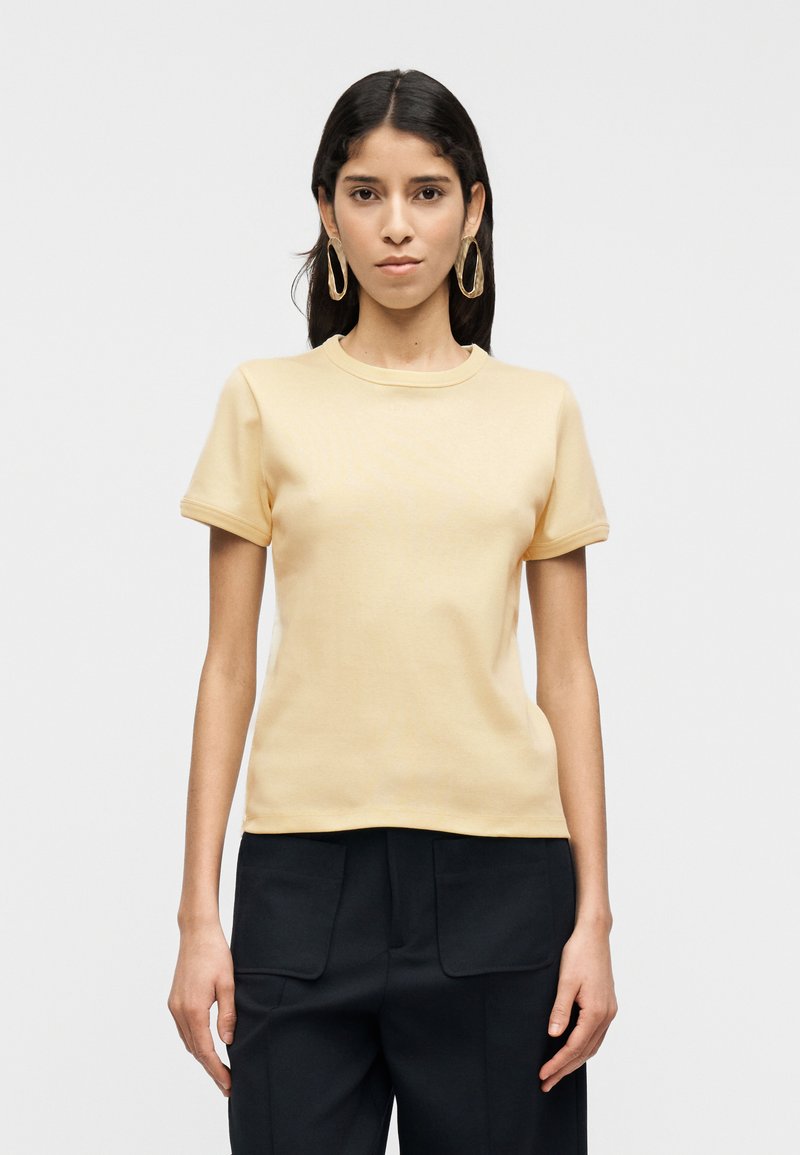 κίτρινο βαμβακερό μπλουζάκι με κοντά μανίκια και στρογγυλή λαιμόκοψη, με απαλό ύφασμα και εφαρμοστή σχεδίαση.