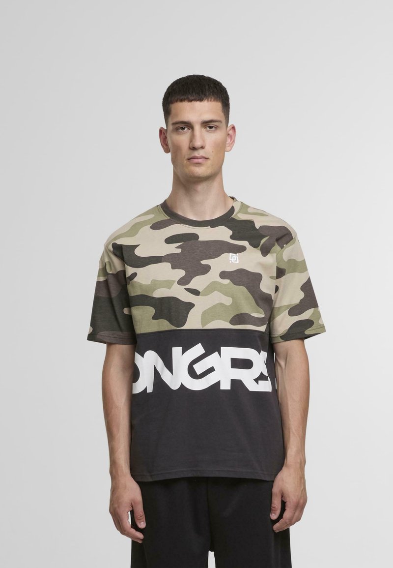 T-shirt κοντομάνικο με καμουφλάζ σχέδιο και μαύρο κάτω μέρος που περιέχει το κείμενο "ONGRA" με έντονα λευκά γράμματα. Από αναμειγμένο βαμβάκι, σε χαλαρή γραμμή.