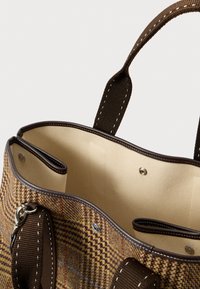 Τσάντα tote από tweed με καφέ δερμάτινες λεπτομέρειες, μπεζ εσωτερικό, δύο ανοιχτές τσέπες, κλείσιμο με κουμπί και φαρδιές ραμμένες υφασμάτινες λαβές.