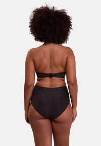Ensemble de bikini noir taille haute avec une finition texturée scintillante. Le haut sans bretelles dispose d'une fermeture par clip à l'arrière.