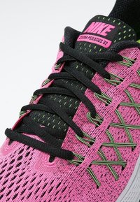 Scarpa da corsa Nike Zoom Pegasus 32 rosa con dettagli neri e verde neon, lacci neri e tessuto in rete traspirante.