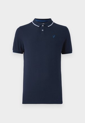 Polo de color azul marino hecho de algodón, con cuello tipo polo, tapeta con dos botones, mangas cortas y un pequeño logo en el pecho.