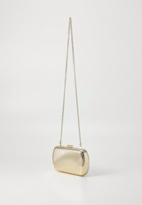 Gold metal clutch bag with a ribbed texture, rectangular shape, and a chain strap. Features a clasp closure on the top.