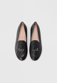 Mocassini neri in pelle con punta arrotondata, caratterizzati da un dettaglio nodo decorativo e accessori in oro e argento sul davanti.