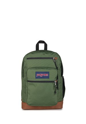 Mochila verde JanSport con múltiples compartimentos con cremallera y base marrón, con asa superior negra y bolsillo lateral de malla.