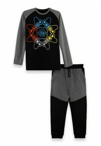 Svart långärmad t-shirt med grå ärmar som har en färgglad grafik av en spelkontroll och matchande grå och svarta sweatpants.