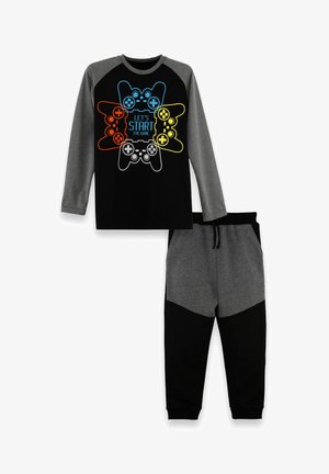 T-shirt noir à manches longues avec des manches grises, présentant un graphisme coloré de manette de jeu et un pantalon de survêtement assorti en gris et noir.