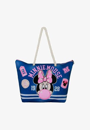 Bolso tote azul con un gráfico de Minnie Mouse, acentos en rosa, un lazo de lunares y varios parches. Tiene un mango de cuerda texturizada.
