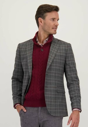 Grijze geruite blazer met een getailleerde pasvorm, gecombineerd met een bordeauxrode kabelgebreide trui en een gemusterde shirt. Gladde textuur met een gestructureerd ontwerp.