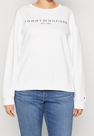 Biała bluza z okrągłym dekoltem, z czarnym logo Tommy Hilfiger i rokiem założenia nadrukowanym na klatce piersiowej. Miękka w dotyku.
