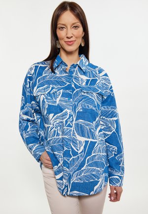 Camicia blu con bottoni, caratterizzata da un motivo a foglie bianche, maniche lunghe e colletto. Tessuto morbido con una vestibilità comoda.