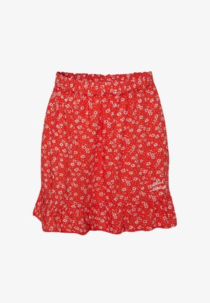Jupe fleurie rouge avec motif marguerite blanche, taille élastique, ourlet à volants et petit texte en cursive en bas à droite.