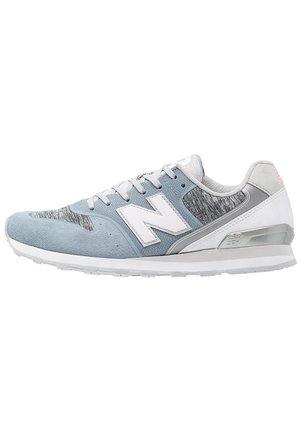 Jasnoniebieski i szary sportowy sneaker z białą podeszwą, białymi sznurowadłami i dużym białym logo "N" po boku.
