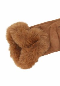 Guanto in suede marrone con un'ampia rifinitura in pelliccia spessa, morbida e soffice attorno al polso, presentato su uno sfondo bianco.