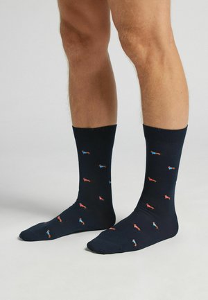 Navy Baumwollsocken mit kleinen roten und blauen Mustern, einem gerippten Bündchen und in Standard-Crewlänge. Glatte Textur, mittlere Dicke.