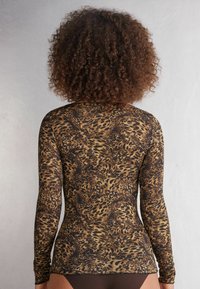 Langärmliges Oberteil mit einem Leopardenmuster in verschiedenen Brauntönen und Schwarz, aus einem dehnbaren Stoff für eine figurbetonte Passform.