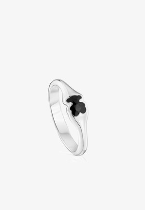 Anillo de plata con un diseño de flor negra facetada incrustado, con una banda lisa y pulida y una forma redondeada.