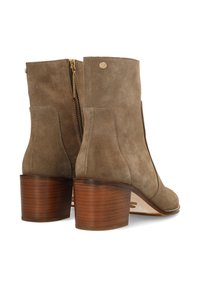 Botines de ante en tono topo con puntera redonda, cremalleras laterales y un tacón de bloque de madera de altura media para mayor estabilidad.