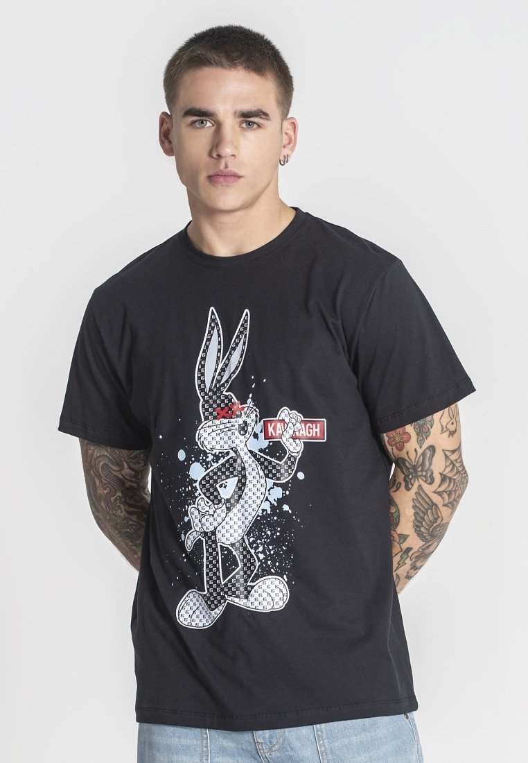 Černé bavlněné tričko s grafikou karikatury králíka s červenými akcenty, umístěné na pozadí s rozstřikovaným designem v různých odstínech modré.
