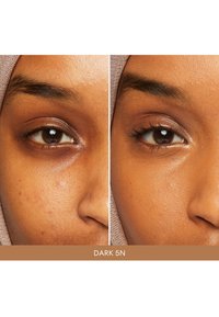 Campione di prodotto cosmetico che mostra due tonalità di pelle affiancate. A sinistra ci sono imperfezioni visibili, mentre a destra appare più liscia e uniforme.