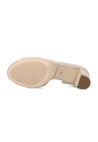 Chaussure à talons hauts en daim beige avec une semelle en caoutchouc texturé, un talon carré et un logo discret sur la semelle intérieure.
