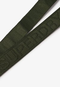 Groene geweven stoffen band met geperst "SUPER"-tekst, met een gladde textuur en vlak ontwerp.