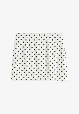 Weißer gerader Rock mit gleichmäßig verteilten schwarzen Polka-Dots und dezenten vorderen Falten, flach auf weißem Hintergrund liegend.