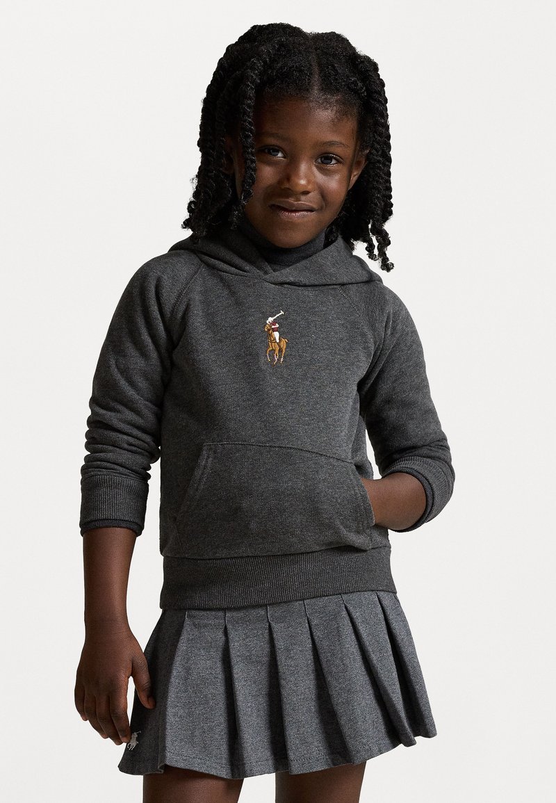 Γκρι φούτερ με καγκουρό τσέπη και κεντημένο λογότυπο καβαλάρη, σε συνδυασμό με πλισέ γκρι φούστα, υφασμάτινο σχέδιο και εφαρμοστή γραμμή.