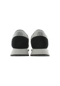 Sneaker nere e grigie con rivestimento in pelle scamosciata, design ergonomico e la dicitura "SINCE 1890" impressa sul tallone. Suola testurizzata per una presa migliore.