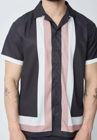 Chemise à manches courtes en bleu marine foncé, présentant des rayures verticales en rose clair, blanc et noir, avec une finition lisse et brillante et une fermeture à boutons.