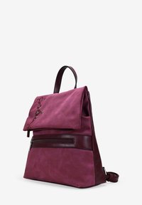 Mochila de tela burdeos con tapa plegable, detalles en cuero, bolsillo frontal con cremallera y bordado floral. Textura suave y forma estructurada.