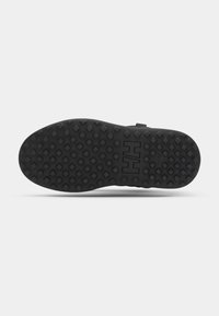 Black rubber shoe sole with a textured surface featuring diamond-shaped patterns and a logo. Flat with a slightly raised heel.
