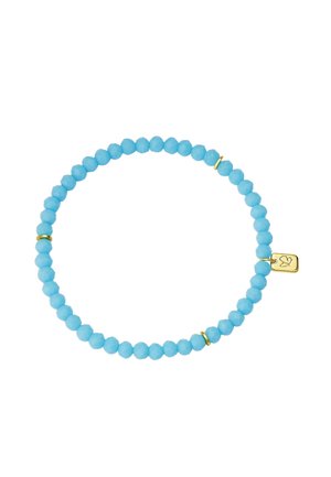Pulsera elástica con cuentas redondas de turquesa, tres anillos pequeños de oro y un pequeño colgante rectangular de oro grabado con un corazón.