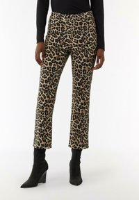 Leopard print pants in tan and black, feature a fitted waist and straight legs. Paired with pointed black wedge ankle boots.
