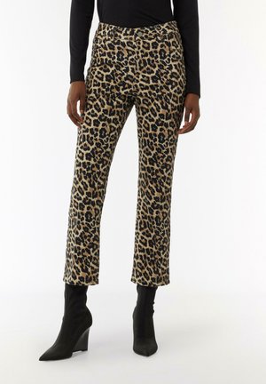 Leopard print pants in tan and black, feature a fitted waist and straight legs. Paired with pointed black wedge ankle boots.