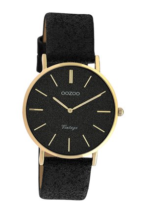 Montre-bracelet OOZOO noire avec boîtier doré, index dorés minimalistes et bracelet en cuir noir texturé affichant l'heure 10:10:09.