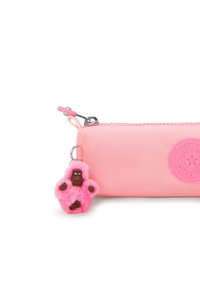 Roze etui met rits van textuurstof, voorzien van een rond reliëflogo en een roze pluche gorilla sleutelhanger eraan bevestigd.