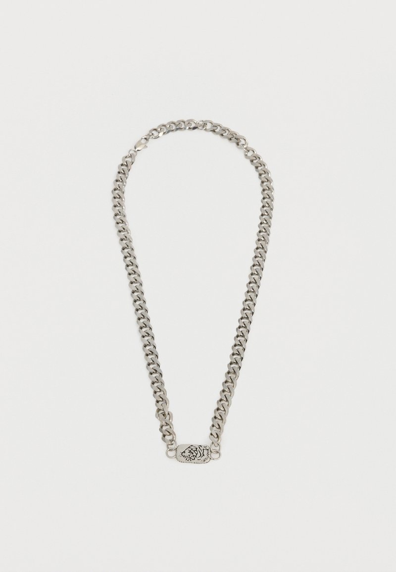 Ασημένιο κολιέ αλυσίδα με παχιά κρίκια και ορθογώνιο μενταγιόν με χαραγμένο σχέδιο κεφαλής τίγρης, τοποθετημένο επίπεδα σε λευκό φόντο.