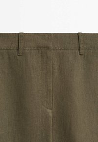 Pantalon en lin kaki avec une finition texturée, doté d'un devant plat, de passants pour ceinture et de poches latérales standard.