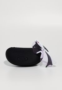 Ochelari de soare cu ramă albă și lentile mov, așezate pe un toc rigid negru, având o finisare texturată și un logo embossat.